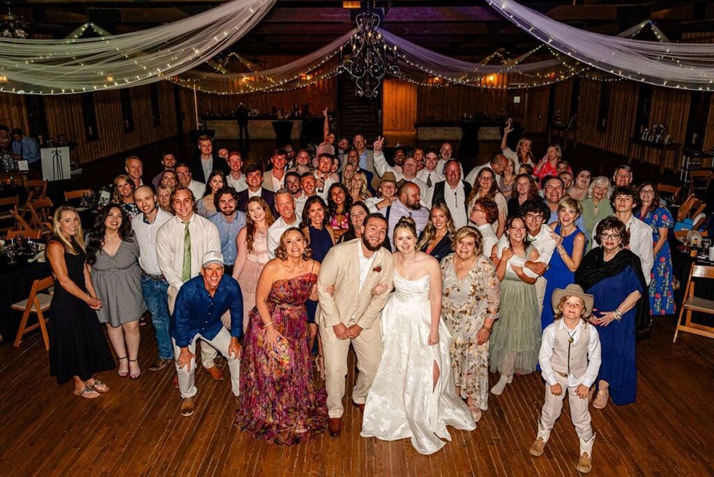 Large group photo of wedding guests inside the reception hall at The Milestone in Boerne Texas