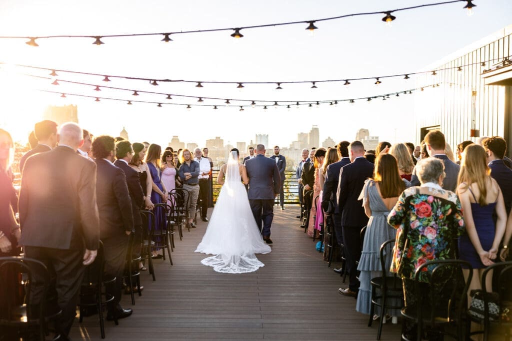Bride and father of the bride walking down the isle from a behind view