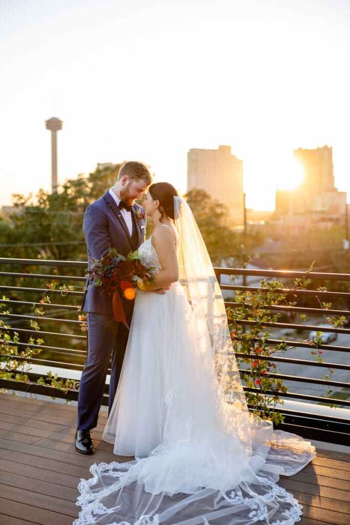 Romantic sunset portrait of bride and groom on the rooftop terrace at The Skyline San Antonio wedding venue.