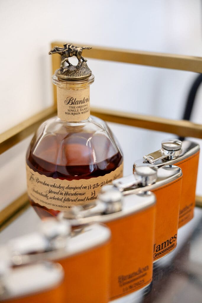 whiskey bottle with individual flasks lined up customized with groomsmen names