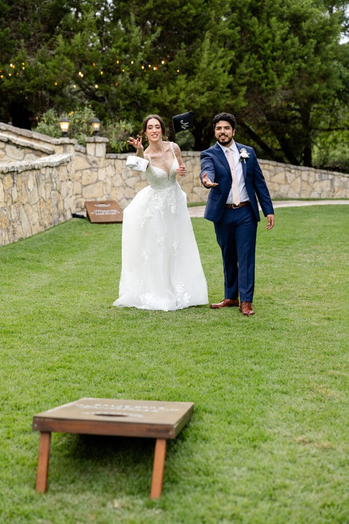 bride and groom playing cornhole