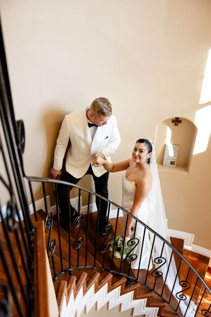 couples portrait in a stair well at the gardens of cranesbury